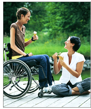 foto av 2 tjejer som äter glass, en sitter i rullstol och en med korslagda ben på marken